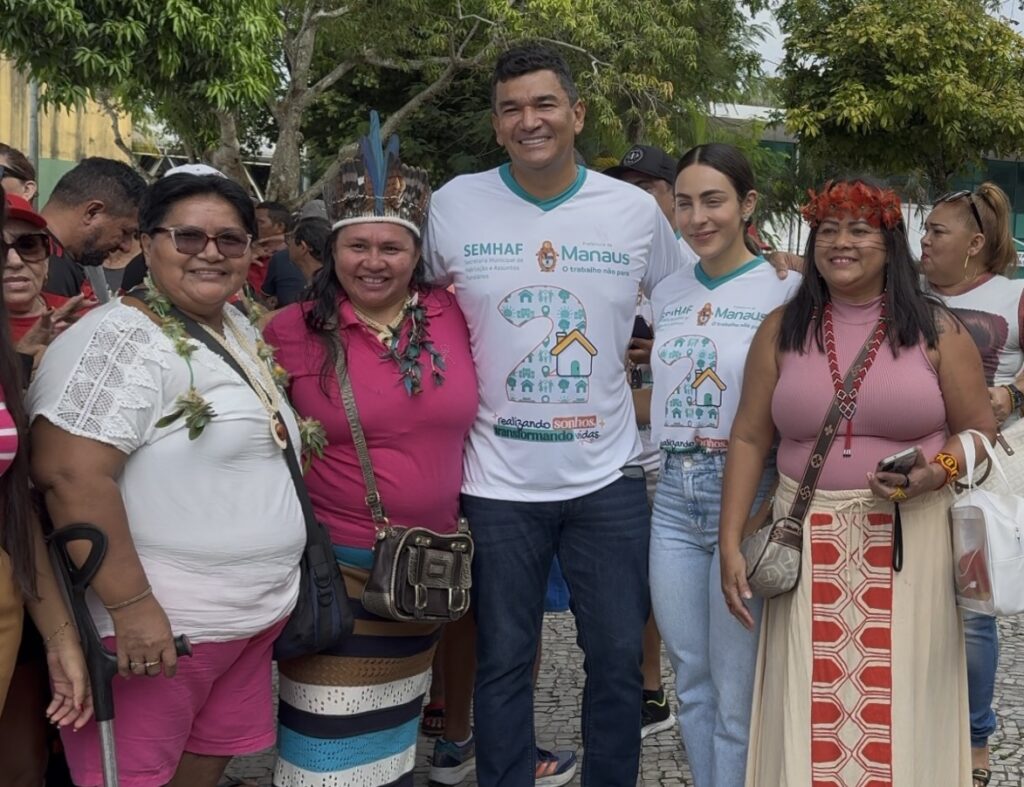 Secretário Jesus Alves ao lado de mulheres durante evento em Manaus ao falar sobre a maioria feminina na busca por moradia no cadastro habitacional.