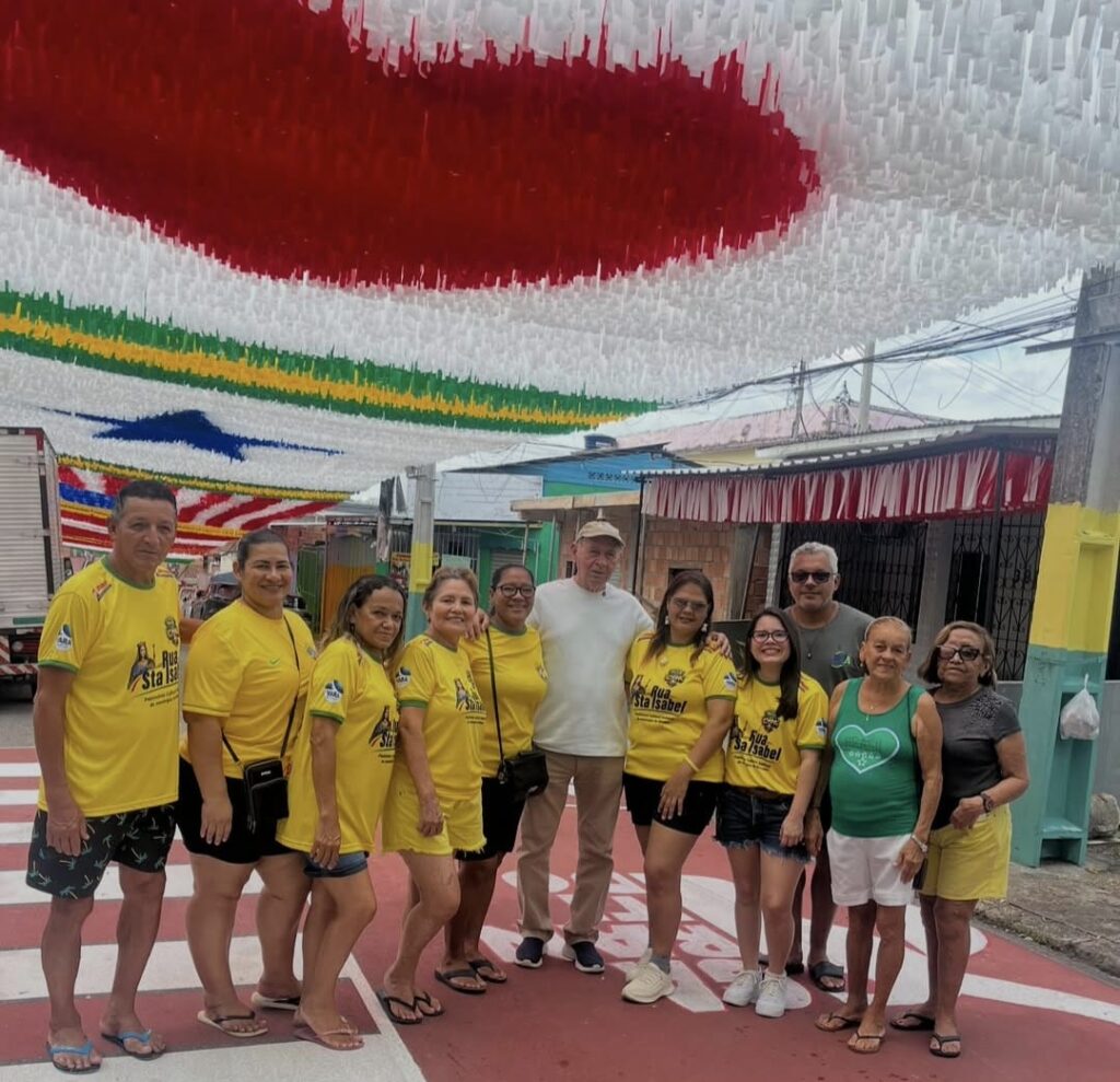 Grupo de moradores posa em rua decorada para a Copa do Mundo durante visita da campanha Rua da Copa da FM do Povo em Manaus.