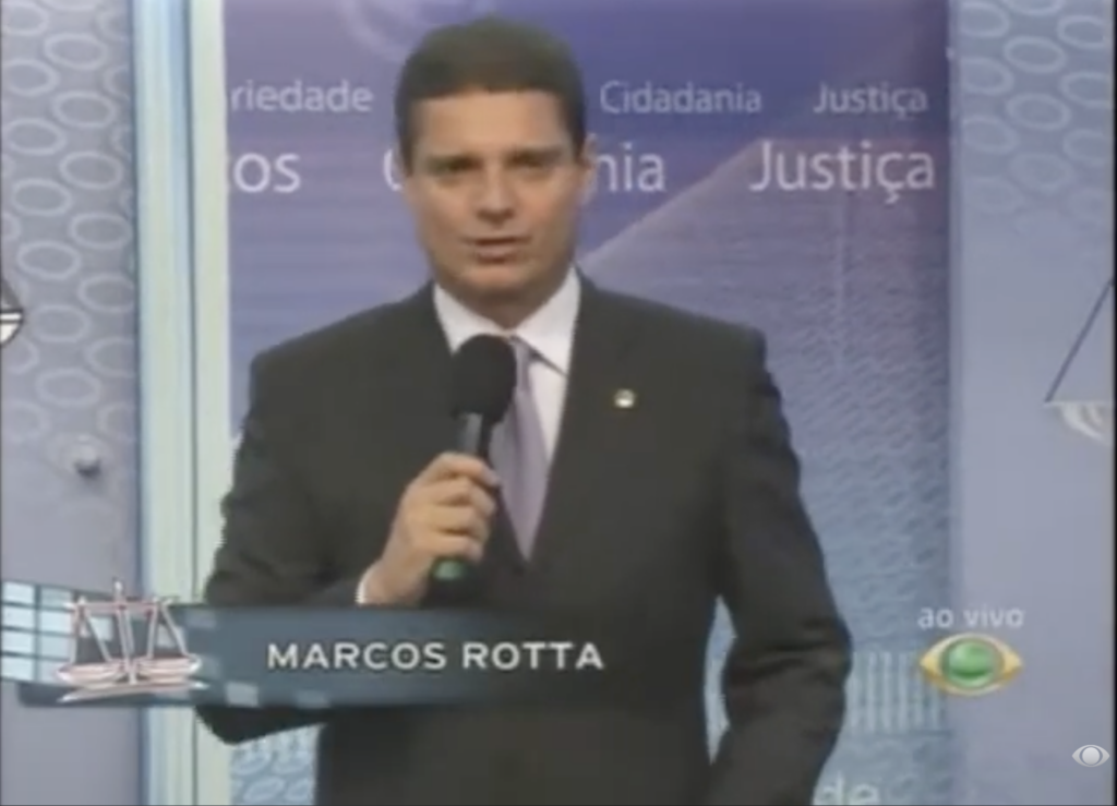 Marcos Rotta apresenta o programa Exija Seus Direitos em estúdio de televisão, durante transmissão voltada à defesa da cidadania e dos direitos da população.