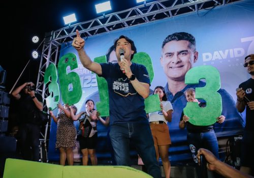 Jender Lobato discursa durante caminhada de encerramento da campanha eleitoral em Parintins, ao lado de apoiadores e do número de campanha.
