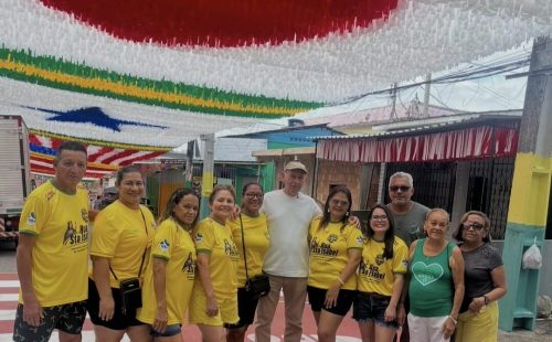 Grupo de moradores posa em rua decorada para a Copa do Mundo durante visita da campanha Rua da Copa da FM do Povo em Manaus.